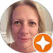 Close-up portrait of a smiling blonde woman with an orange Google Local Guide star icon.